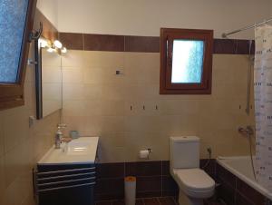 a bathroom with a toilet and a sink and a tub at Stamoulis Garden House in Katigiorgis +5 photos