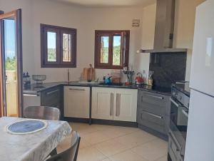 a kitchen with white cabinets and a table with a table sidx sidx at Stamoulis Garden House in Katigiorgis