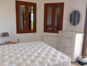 a bedroom with a bed and a dresser and a mirror at Stamoulis Garden House in Katigiorgis