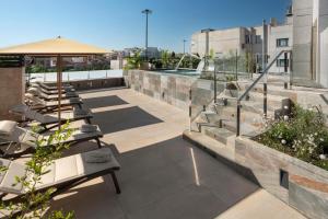 a rooftop patio with tables and an umbrella at Catalonia El Retiro in Madrid