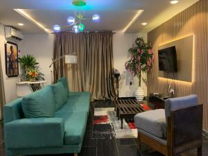 a living room with a blue couch and a chair at Weltons Apartments in Ikeja