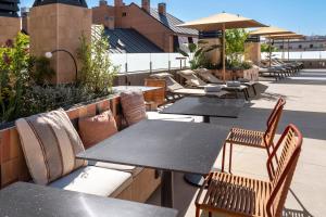 a row of tables and chairs on a rooftop patio at Catalonia El Retiro in Madrid