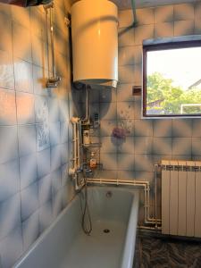 a bathroom with a bath tub and a window at Apartman 23 in Kraljevo +8 photos