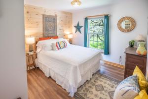 a bedroom with a white bed and a window at Seascape Serenity with Epic Coastal Views! in Lubec