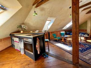 an attic living room with an oven and a dining room at Apartmány Za branou in Kutná Hora