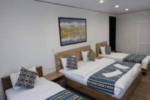 a room with three beds and two couches at Apricot Lodge in Bishkek +175 photos