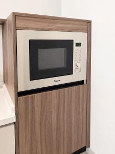 a microwave oven on top of a wooden cabinet at Ghosen Al Zaitoon chalet in Sayq +6 photos