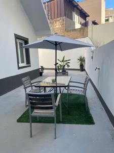 a table and chairs with an umbrella on a patio at Domus de janas 2 in Alghero