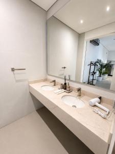 a bathroom with two sinks and a large mirror at Ghosen Al Zaitoon chalet in Sayq