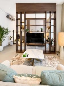 a living room with a couch and a television at Ghosen Al Zaitoon chalet in Sayq