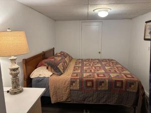 a small bedroom with a bed and a lamp at Oasis Studio in Cambridge