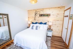 a bedroom with a white bed and a wooden wall at Seascape Serenity with Epic Coastal Views! in Lubec