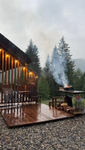 a wooden deck with a grill and a table and chairs at Ліс Снів in Tatariv