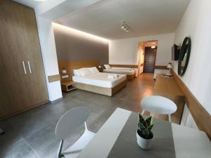 a hotel room with a bed and a table and chairs at ISALOS GERAKiNi in Yerakiní