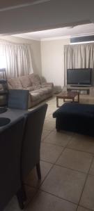 a living room with a couch and a table at Schubert Self Catering Accomodation in Brackenfell