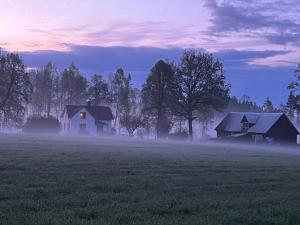 two houses in the middle of a field at dusk at Askebo Norregård in Askebo