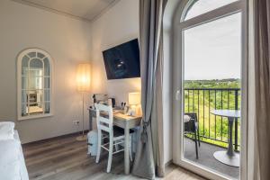 a room with a bed and a desk and a balcony at Von Landsberg in Hennef