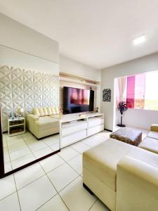 a living room with a bed and a tv and a couch at Apartamento Park Vinhais in São Luís