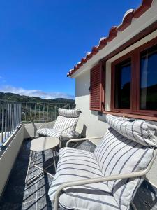 three chairs and a table on a balcony at Maurícius Village in Santa Cruz