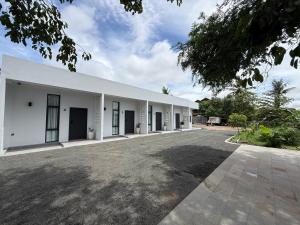 a large white building with a parking lot at Family Motel in Bahal