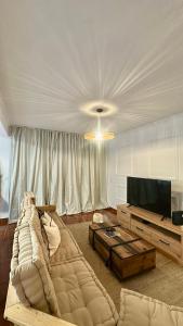 a living room with a large couch and a television at Maurícius Village in Santa Cruz