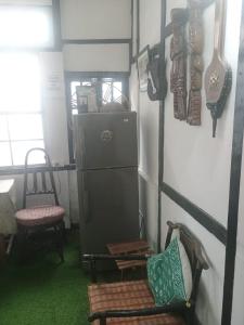 a room with a refrigerator and chairs and a table at Royal Pine Homestay in Shillong