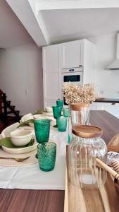 a kitchen with green bowls and plates on a table at Maurícius Village in Santa Cruz