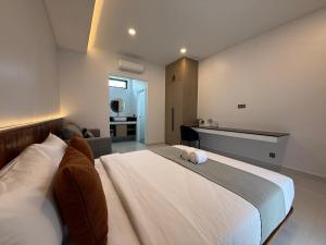 a bedroom with a large white bed and a kitchen at Family Motel in Bahal +28 photos
