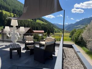 a patio with chairs and a table with a view at SONNLEITEN Alpin Hotel in Cadipietra