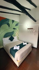 a bedroom with a bed with two towels on it at Tour La Matrona in Villa de Leyva
