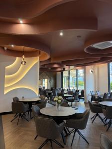 a restaurant with tables and chairs and windows at Hotel Ricardo Residence in Ulcinj