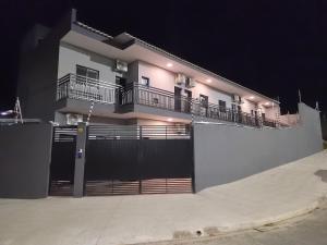 a large white building with a fence and a balcony at Loft 10 com ar-condicionado da Rede Urbana in Indaiatuba