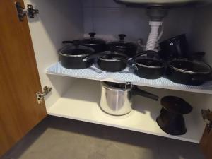 a shelf with several pots and pans on it at Loft 10 com ar-condicionado da Rede Urbana in Indaiatuba +11 photos