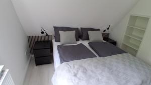 a small bedroom with a bed and two lamps at Haus Küstenglück in Neuharlingersiel