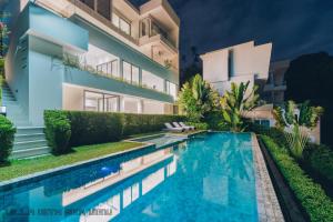 a villa with a swimming pool in front of a building at AAA villa in Ban Bang Po