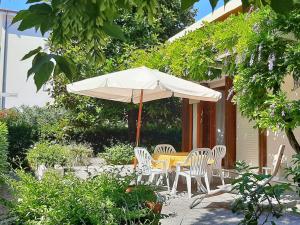 a table and chairs and an umbrella on a patio at Villa Lilly in Grado