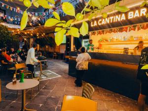 a woman walking past a bar in a restaurant at Viajero CDMX Centro Hostel in Mexico City +77 photos