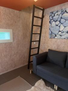 a living room with a ladder next to a couch at Mini house Imatra with own garden in Imatra