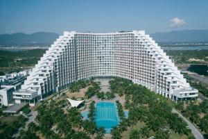 an aerial view of a large building with a pool at The Sea Beach Residences - Arena Cam Ranh Resort in Cam Ranh International Airport