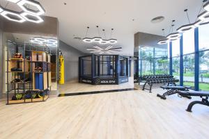 a gym with benches and dumbbells in a room at The Sea Beach Residences - Arena Cam Ranh Resort in Cam Ranh International Airport