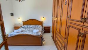 a small bedroom with a bed and wooden cabinets at Casa Gala in Mamoiada