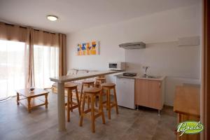 cocina y sala de estar con mesa y sillas en Bungalows Papalus - Golf Lloret -, en Lloret de Mar