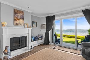 a living room with a fireplace and a view of the ocean at 111 Water Street Inn in Boyne City +2 photos