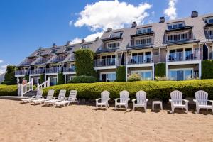 a row of chairs on the beach in front of a building at 111 Water Street Inn in Boyne City