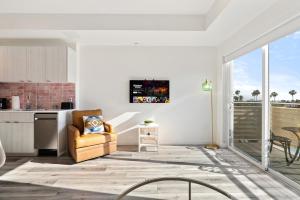 a living room with a yellow chair and a kitchen at Modern Hollywood Studio, Pool Parking Gym in Los Angeles