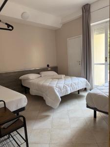 a bedroom with two beds and a window at Hotel BENGASI Marina Centro in Rimini
