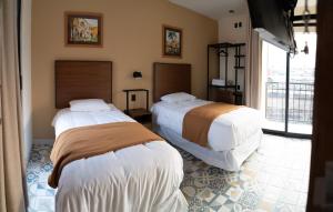 a bedroom with two beds in a room at Hotel Posada de Piedra in Orizaba