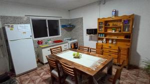 a kitchen with a table and a white refrigerator at La Niña in Belén +3 photos