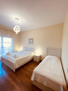 a bedroom with two beds and a chandelier at Shkodra Central Corner in Shkodër
