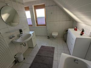 a white bathroom with a sink and a toilet at FeWo am Heimlisberg in Friesenheim +16 photos